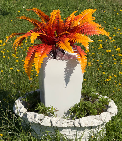 O plantă artificială mare, realistă, ferigă Boston – în culori de toamnă (de la portocaliu-galben până la roșu intens),  ghiveci și pietriș decorativ